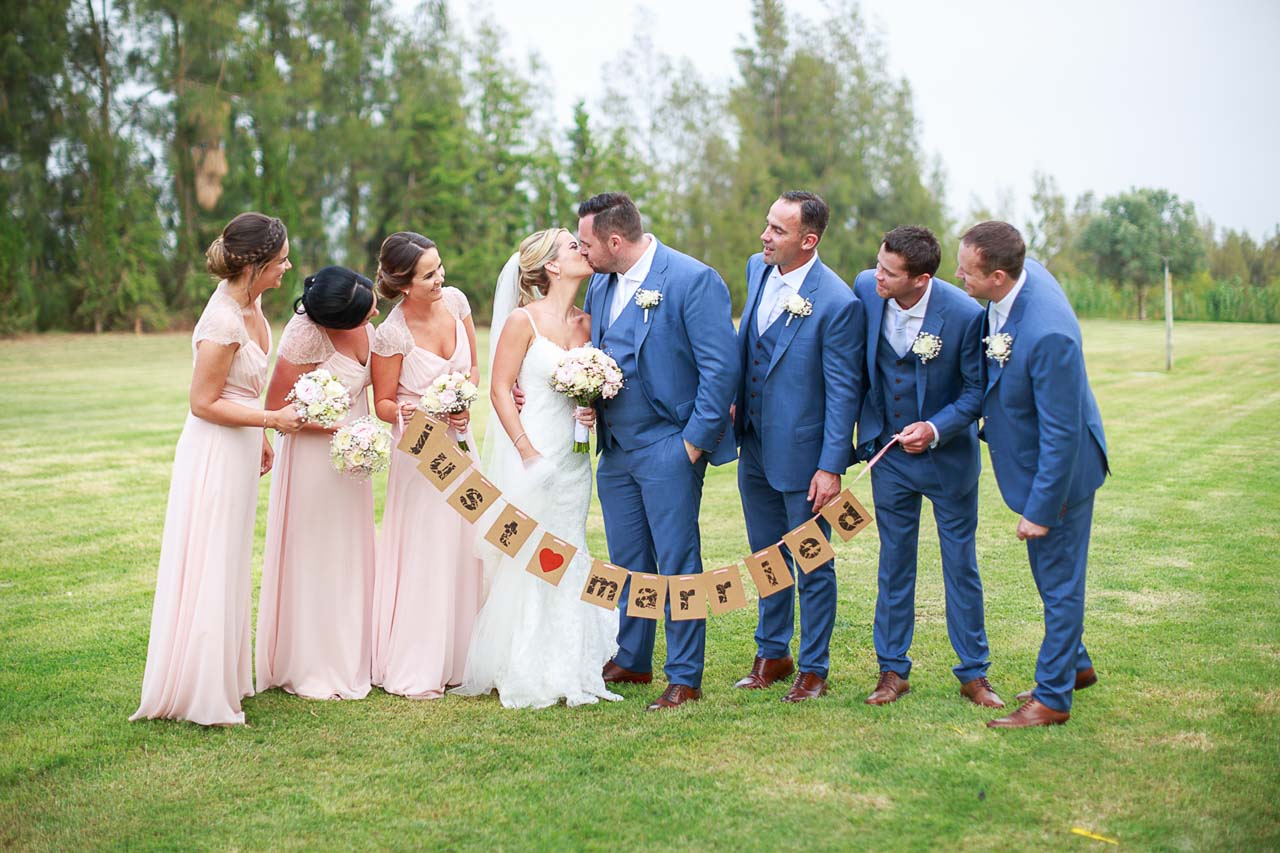 couple and bridal party in a nature environment with just married lettering