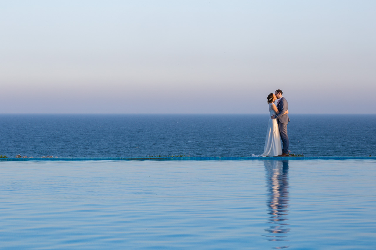 couple in infinite pool with ocean in the background